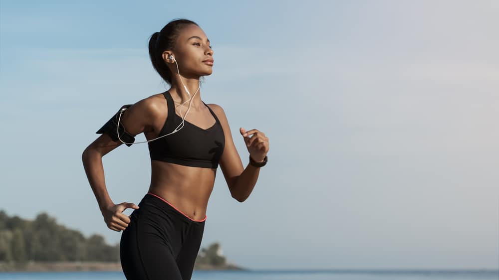 Young-fit-woman-running-while-listening-to-music-on-phone