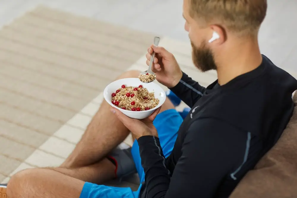 oung-man-in-athletic-clothing-eating-granola-and-fruit